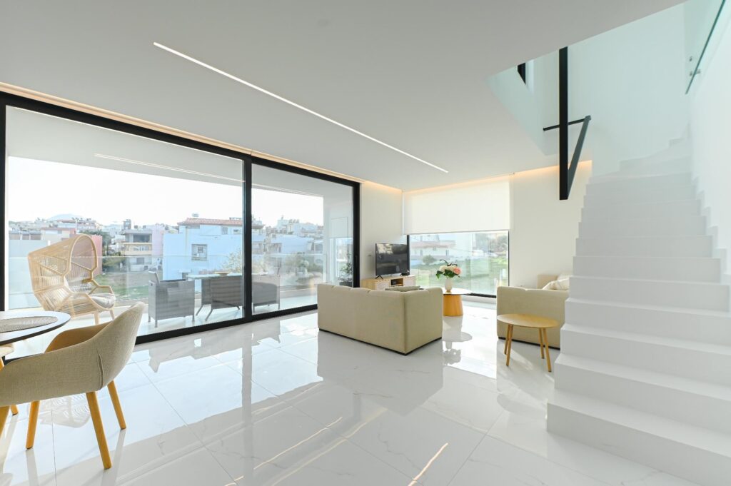 Open-plan living room of the Executive Deluxe Suite with floor-to-ceiling windows and city view