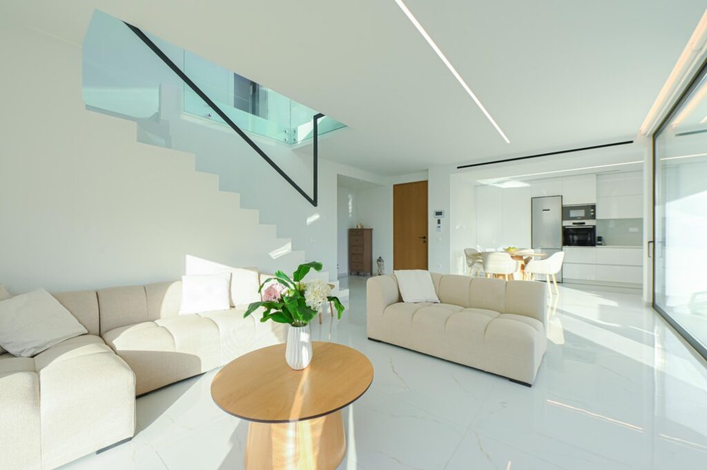 Beige sofa and round wooden coffee table in the Executive Deluxe Suite living room, Heraklion