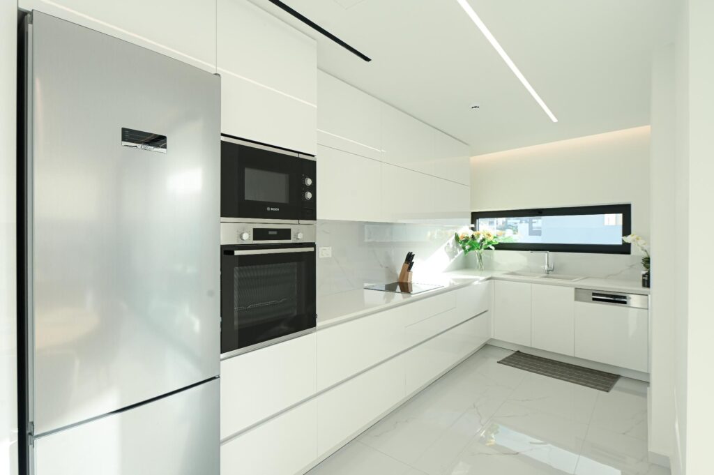 Modern kitchen with fridge, microwave and built-in oven in the Executive Deluxe Suite apartment