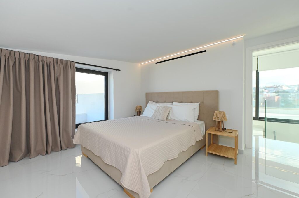 Double bed with upholstered headboard and bedside lamps in the Executive Deluxe Suite