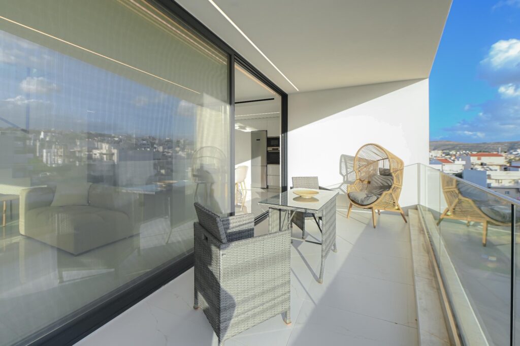 Private balcony with armchairs seen through the glass doors of the Executive Deluxe Suite