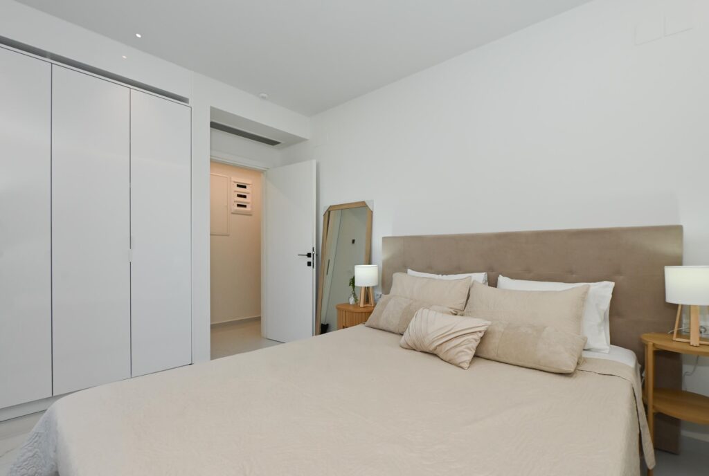 Double bedroom with mirror, wardrobe and bedside lamps in the Executive Deluxe Suite