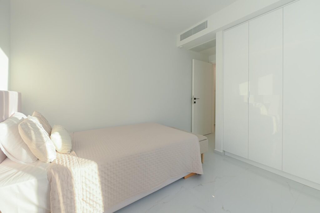 Double bed with knitted throw and built-in wardrobe in the Executive Deluxe Suite